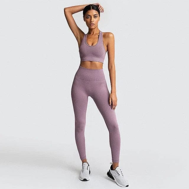 Woman in lavender sportswear set, featuring a classic cut sports bra and high-waisted leggings, paired with white sneakers. Fitness fashion.
