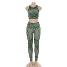 Green snakeskin print sports set on mannequin, featuring a sleeveless crop top and high-waisted leggings. Perfect for yoga and fitness enthusiasts.