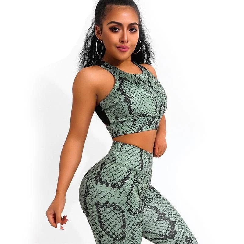 Green snakeskin print sports set for women, featuring a sleeveless crop top and high-waisted leggings. Trendy activewear fashion outfit.