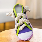 Colorful sneaker with thick rope laces, featuring a purple and green design, displayed on a wooden surface. Unique footwear, trendy shoe design.