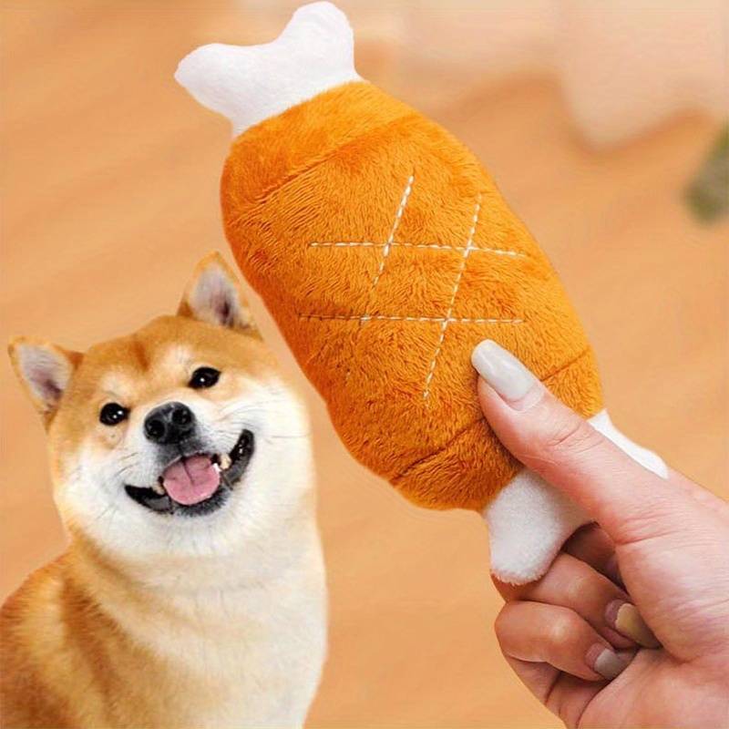 Shiba Inu dog excitedly looking at a plush toy shaped like a drumstick. Cute pet toy, dog accessory, playful Shiba Inu, pet supplies.