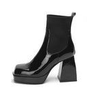 Sleek black patent leather ankle boot with chunky block heel and square toe, perfect for fashion-forward style and comfort. Women's footwear trend.