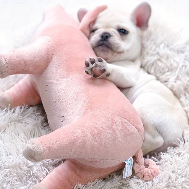 French Bulldog puppy cuddling a pink plush toy on a fluffy white rug. Cute dog, adorable pet, cozy setting, playful puppy, soft toy.