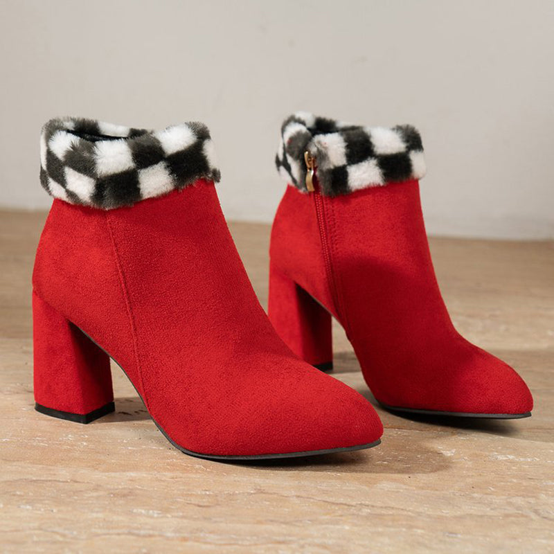 Red suede ankle boots with black and white plaid faux fur trim, featuring a chunky heel and side zipper. Stylish women's winter footwear.