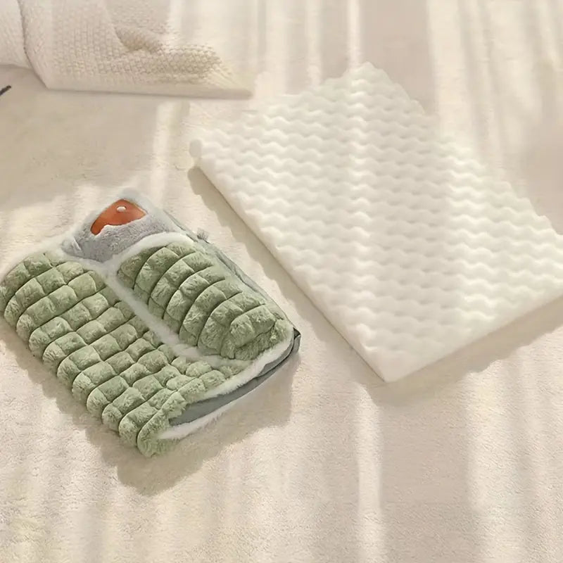 Green plush hot water bottle cover with a cozy, quilted design next to a white textured foam mat on a soft beige surface, perfect for relaxation.