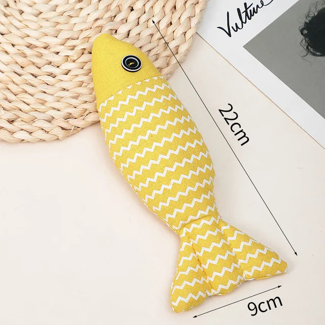 Yellow fish-shaped cat toy with white zigzag pattern, measuring 22cm by 9cm, on a woven mat. Ideal for pet play, durable and stylish design.