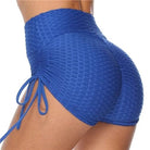 Blue high-waisted ruched sports shorts with side tie detail, textured fabric, perfect for gym workouts, yoga, and activewear fashion.