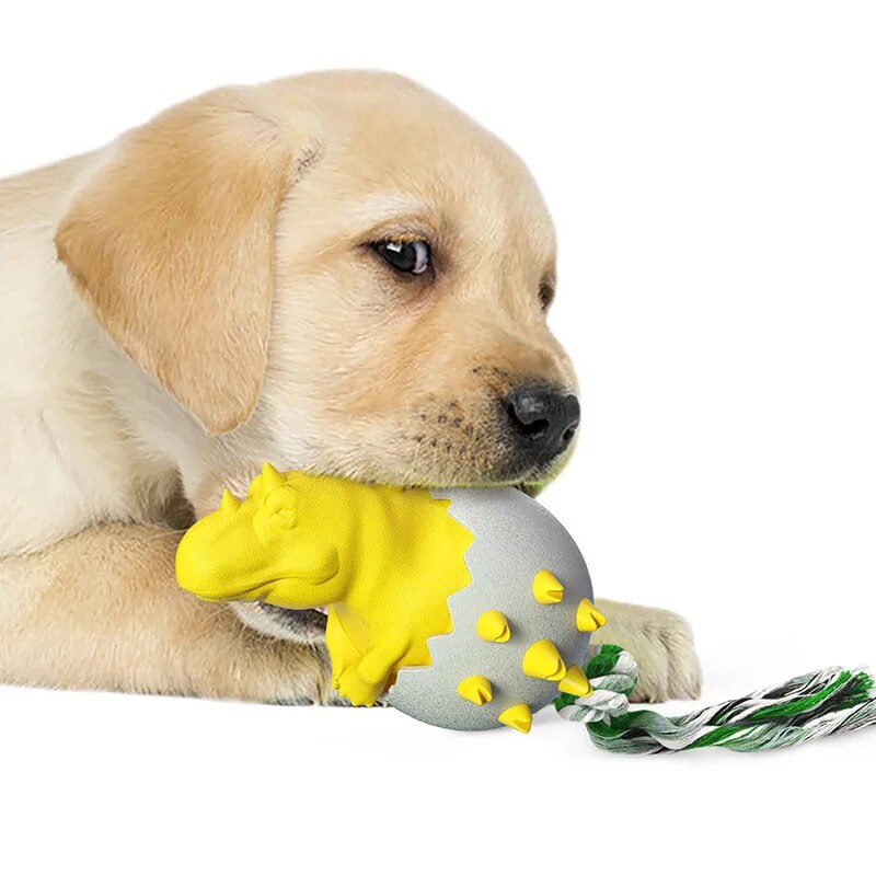 Yellow Labrador puppy chewing on a yellow dinosaur-shaped dog toy with a rope, promoting durable pet toys for playful puppies.