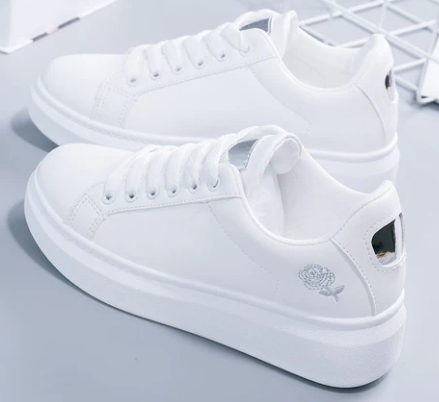 White platform sneakers with rose embroidery, featuring lace-up design and thick soles. Stylish casual footwear for women. Fashionable and comfortable shoes.