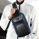 Man wearing a white jacket holding a stylish black and navy crossbody sling bag with multiple compartments, ideal for travel and daily use.