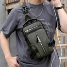 Trendy olive green crossbody bag with multiple zippers and adjustable strap, worn by a person in a casual gray t-shirt, ideal for urban fashion.