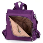 Purple nylon backpack with open front zipper pocket, showcasing spacious interior and multiple compartments. Ideal for travel, school, or daily use.