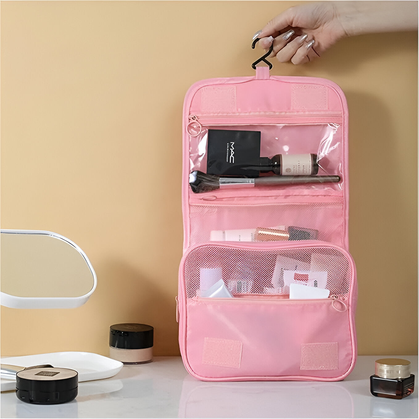 Hanging pink travel toiletry bag with transparent compartments, holding makeup and skincare products, ideal for organized storage and easy access.