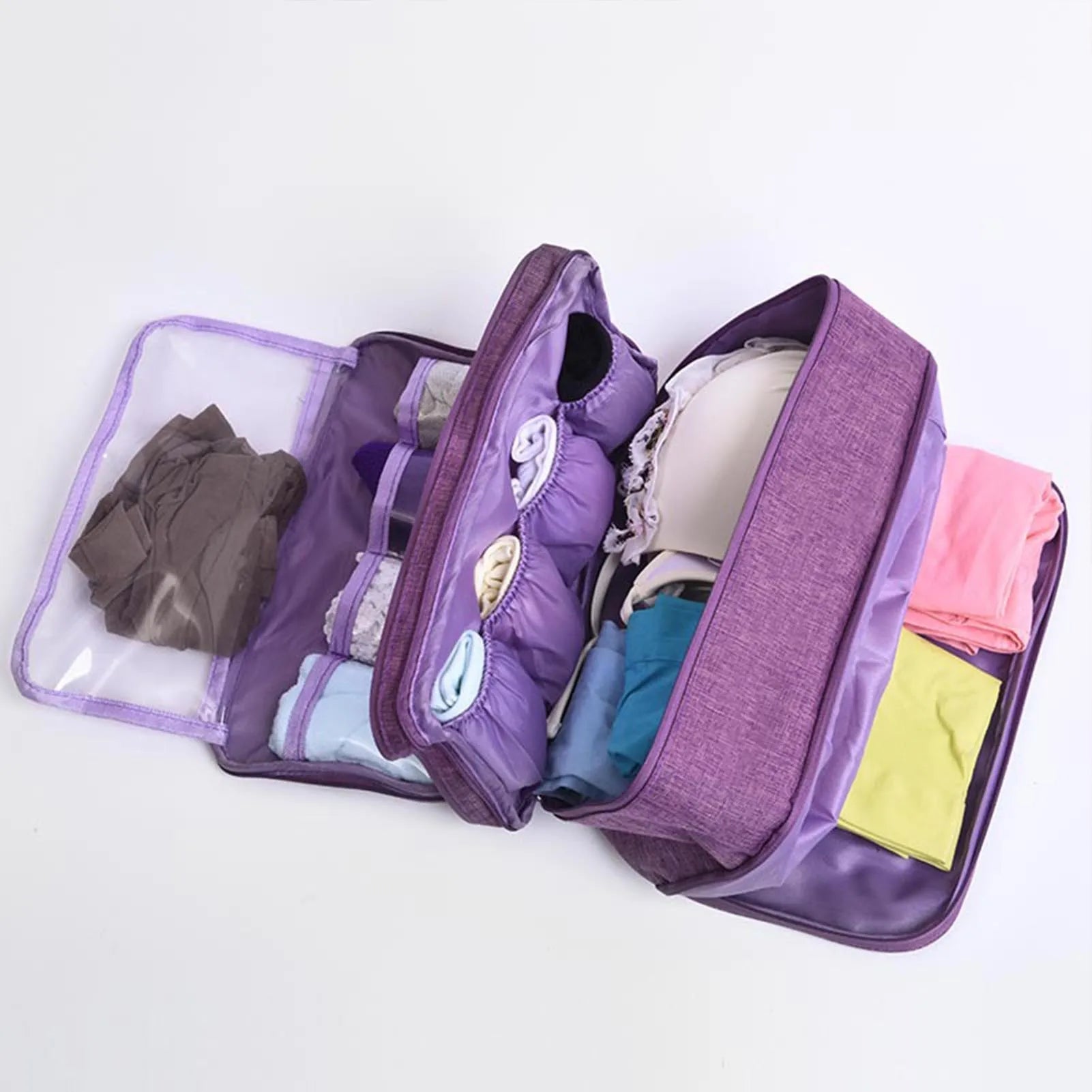 Purple travel organizer bag with multiple compartments, showcasing neatly packed clothes, underwear, and accessories. Ideal for efficient packing and storage.