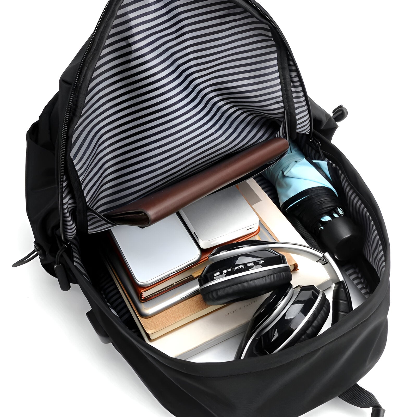 Open black backpack with striped interior, containing a laptop, notebooks, headphones, and a water bottle. Ideal for travel and work essentials.