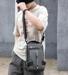 Stylish gray crossbody bag with multiple compartments, worn by a person in casual attire. Perfect for urban fashion and practical everyday use.