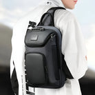 Sleek black leather backpack with multiple compartments, worn by a person in a white jacket. Stylish, modern design ideal for travel and daily use.