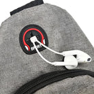 Gray backpack with built-in headphone port, featuring white earphones. Ideal for travel and sports. Durable fabric, modern design, convenient audio access.