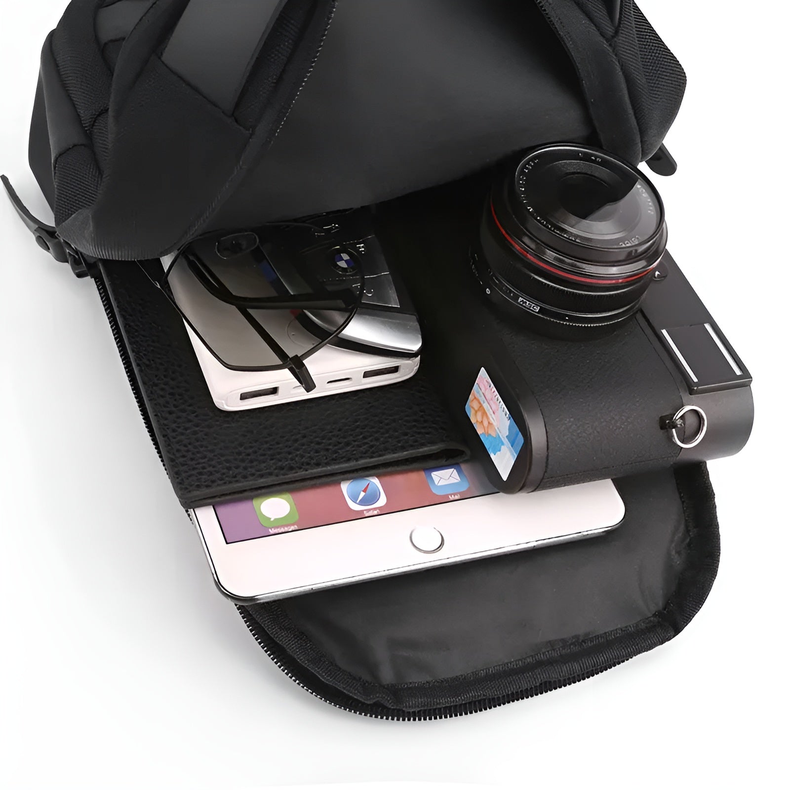 Open backpack with camera, tablet, smartphone, and glasses inside. Perfect for travel and photography enthusiasts. High-quality gear storage solution.