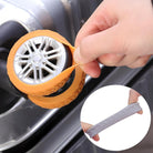 Hand applying orange silicone tire cover on a silver suitcase wheel, with an inset showing a gray tire cover. Durable luggage wheel protector.