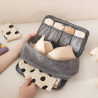 Travel bra organizer with multiple compartments, holding bras and underwear. Compact, portable storage solution for efficient packing.