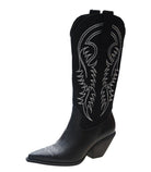 Black knee-high leather cowboy boots for women with intricate white embroidery, featuring a pointed toe and angled heel. Fashionable Western footwear.