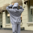 Gray hoodie and sweatpants set, casual loungewear, outdoor urban setting, comfortable fit, street style fashion, cozy sweatshirt outfit.