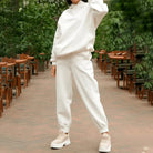 White sweatshirt set with joggers, worn by a person outdoors. Casual, comfortable loungewear fashion, perfect for relaxed, stylish looks.