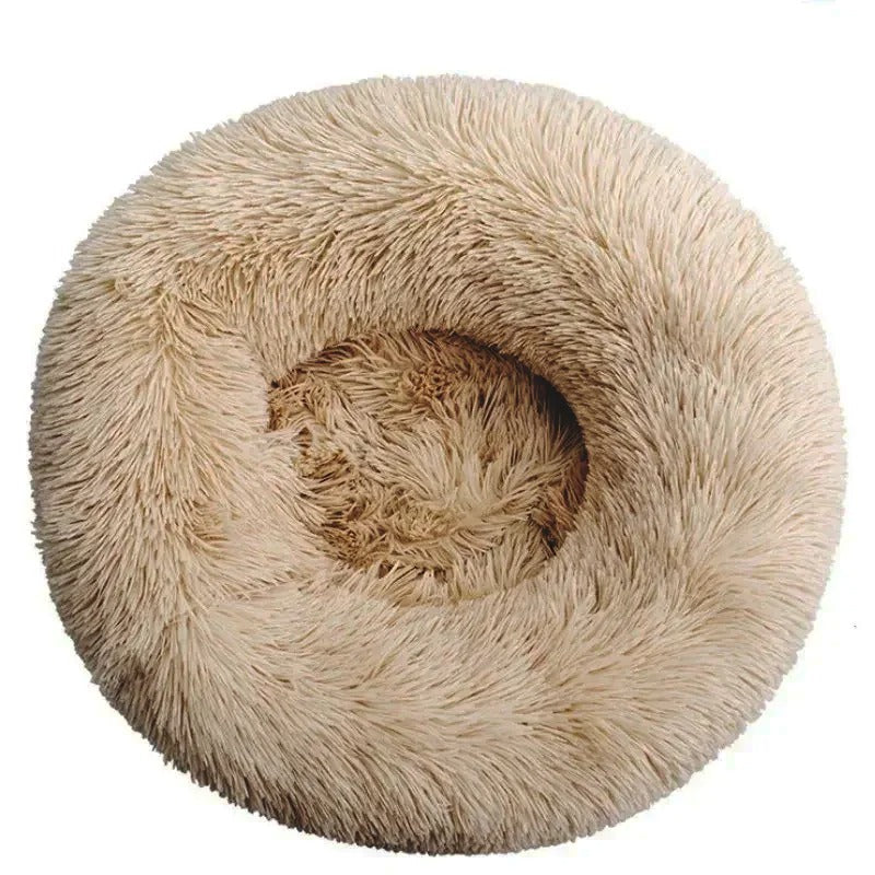 Round beige fluffy pet bed, donut shape, plush faux fur, cozy and comfortable for cats and small dogs, ideal for relaxation and warmth.