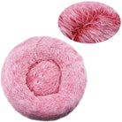 Pink fluffy round pet bed with soft faux fur texture, ideal for cats and small dogs. Cozy, comfortable, and stylish pet accessory.