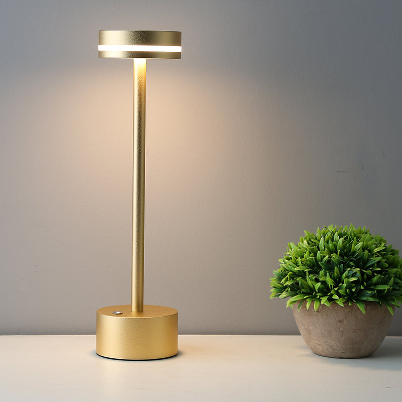 Modern gold LED table lamp with sleek design, illuminating a minimalist space. Energy-efficient lighting, perfect for contemporary home decor.