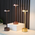 Modern LED table lamps in bronze, copper, and gold finishes on display; sleek design, energy-efficient lighting, perfect for contemporary home decor.