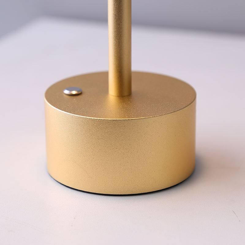 Gold lamp base with a sleek cylindrical design, featuring a metallic finish and a small button. Ideal for modern home decor and lighting solutions.