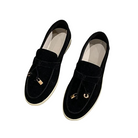 Black suede loafers with gold metal accents, slip-on design, and white soles. Stylish men's footwear, perfect for casual and formal occasions.