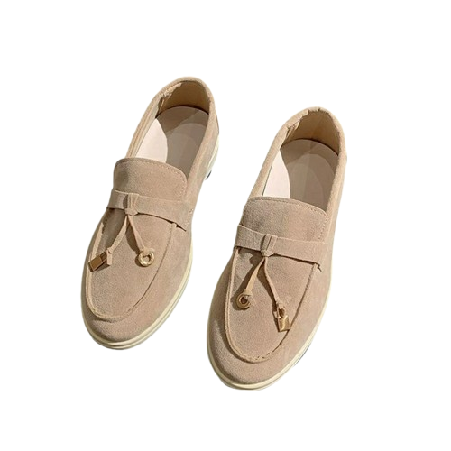 Beige suede loafers with tassel detail, slip-on design, and white soles. Stylish men's casual footwear, perfect for versatile fashion looks.