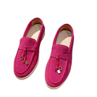 Bright pink suede loafers with decorative tassels, slip-on design, and white soles. Stylish women's footwear, perfect for casual and formal outfits.