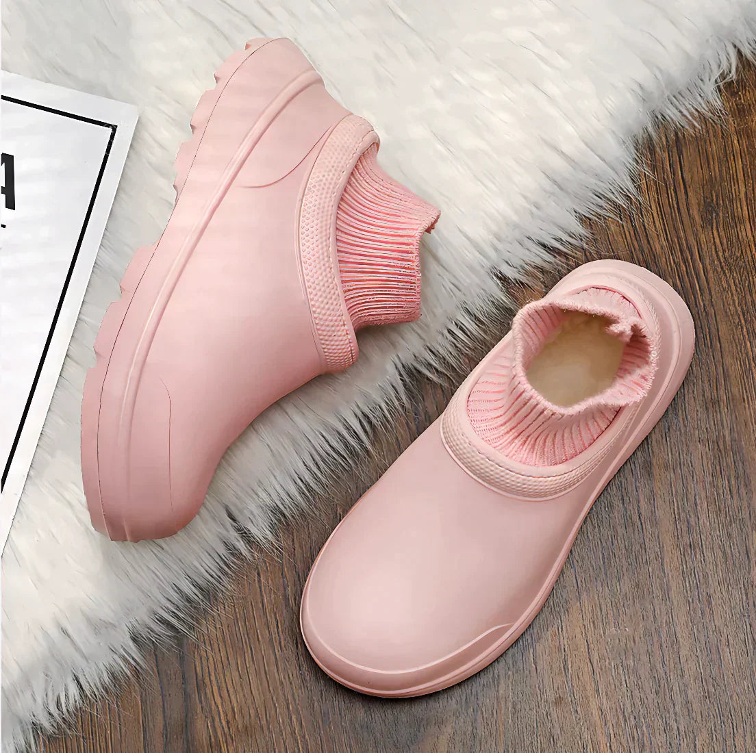 Pink slip-on shoes with cozy knit cuffs on a wooden floor and white fur rug, perfect for casual wear. Stylish, comfortable footwear for women.