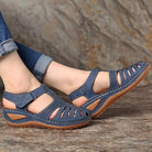 Blue orthopedic sandals with low heel, breathable design, and correction function, worn with rolled-up jeans. Ideal for comfort and support.