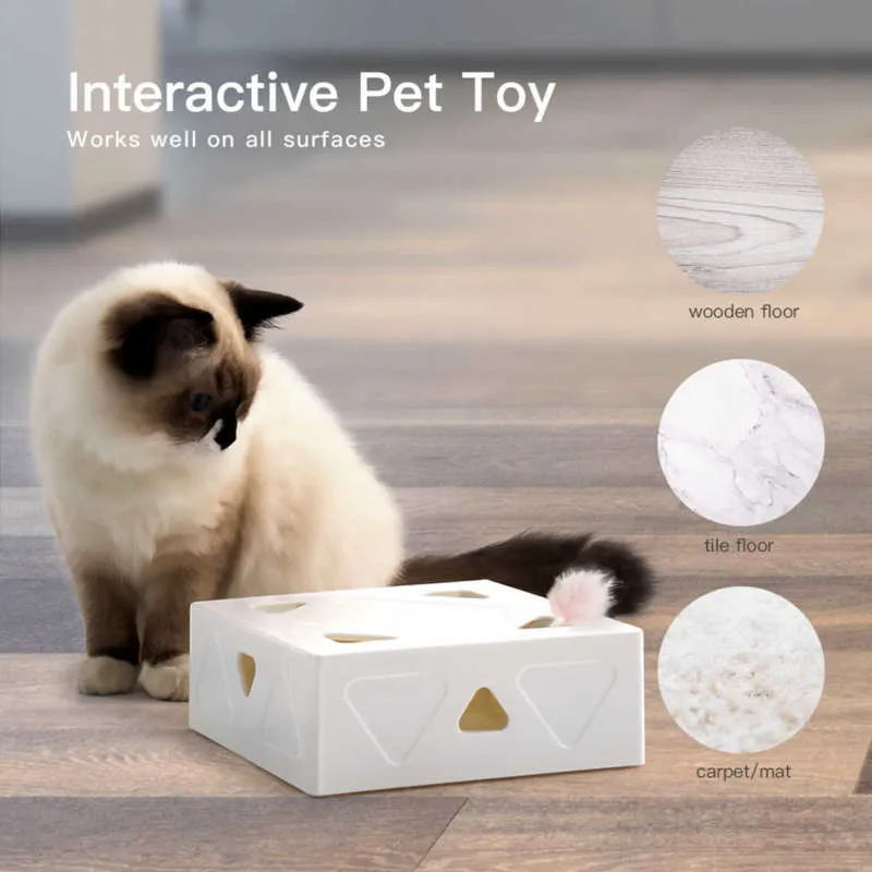 Interactive pet toy for cats on wooden floor, featuring a white box with cutouts and a pink feather. Suitable for wooden, tile, and carpet surfaces.