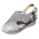 Silver glitter wedge sandal with open toe, adjustable ankle strap, and textured platform sole. Stylish women's footwear for summer fashion.