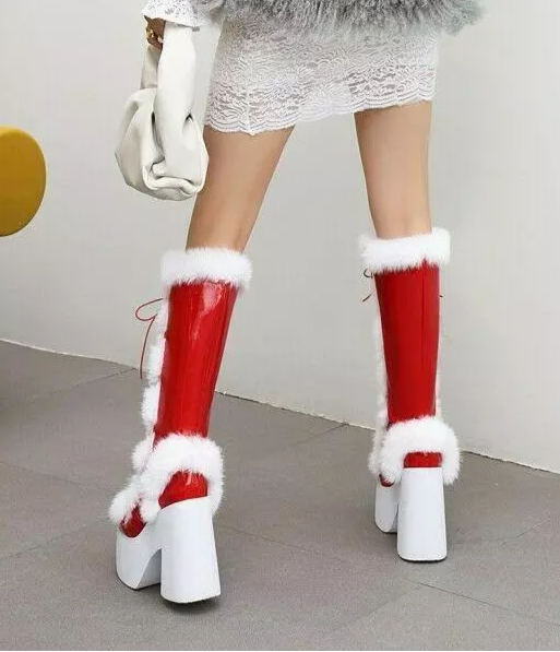 Red and white knee-high platform boots with fur trim, featuring high block heels. Stylish winter footwear for women, perfect for festive occasions.