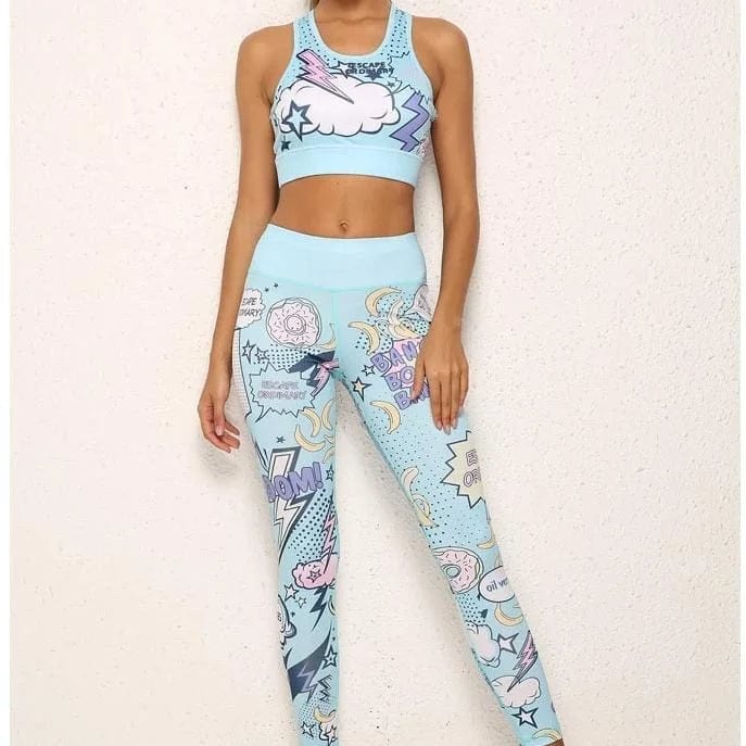 Woman wearing blue comic-style sportswear set with cloud and lightning designs, standing against a white background. Trendy activewear fashion.