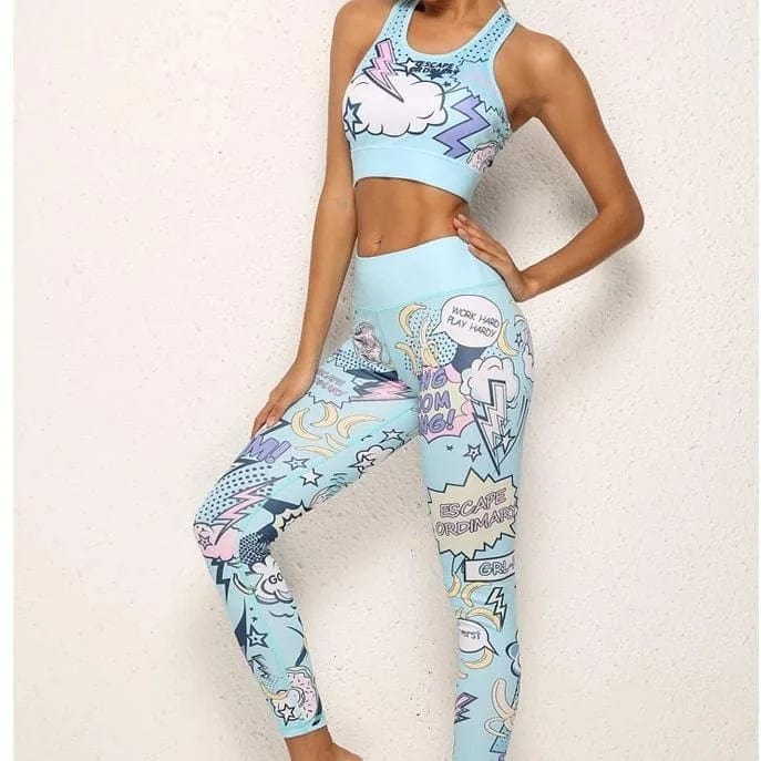 Woman wearing blue comic-style sports bra and leggings set with colorful graphics, standing against a white background. Trendy activewear fashion.