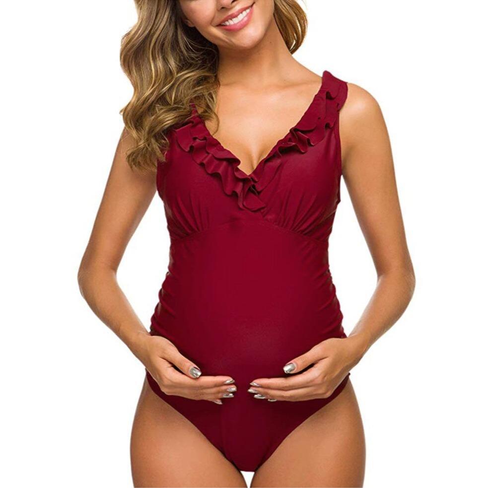 Maternity swimsuit in burgundy with ruffled neckline, designed for pregnant women. Comfortable, stylish swimwear for expectant mothers.