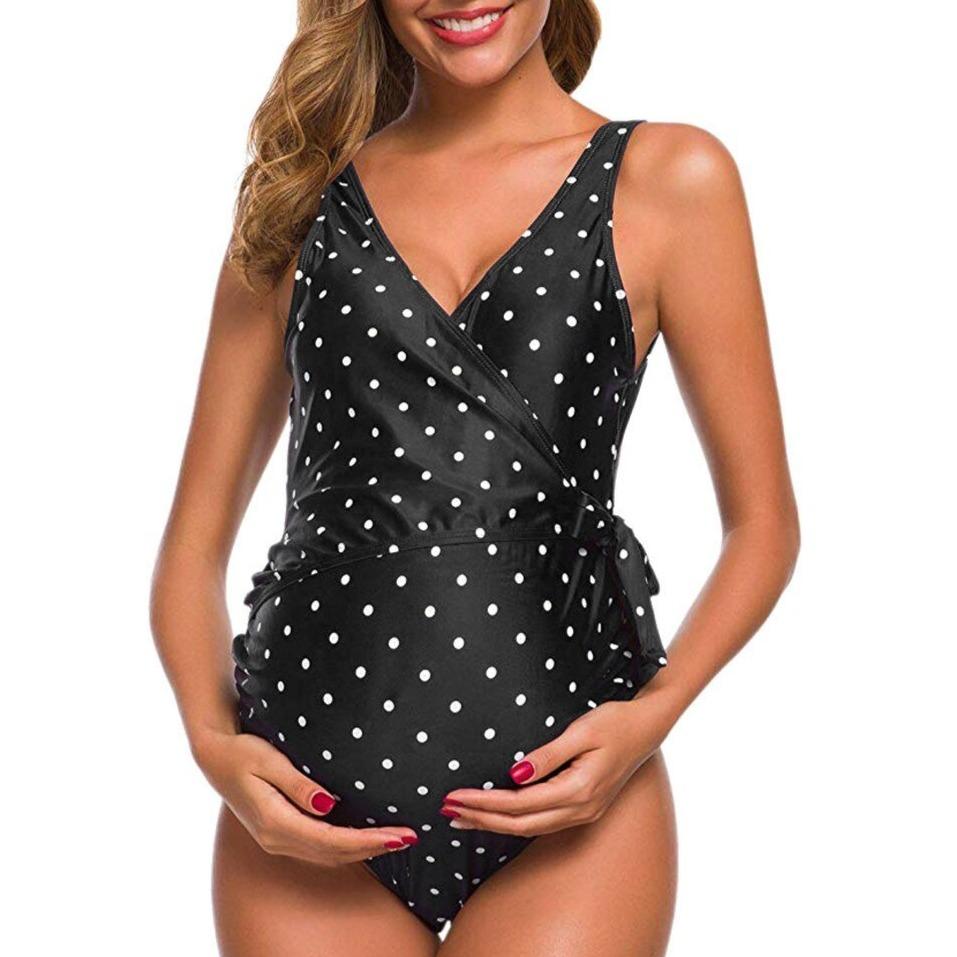 Maternity swimsuit in black with white polka dots, featuring a wrap design. Ideal for pregnant women seeking stylish and comfortable swimwear.