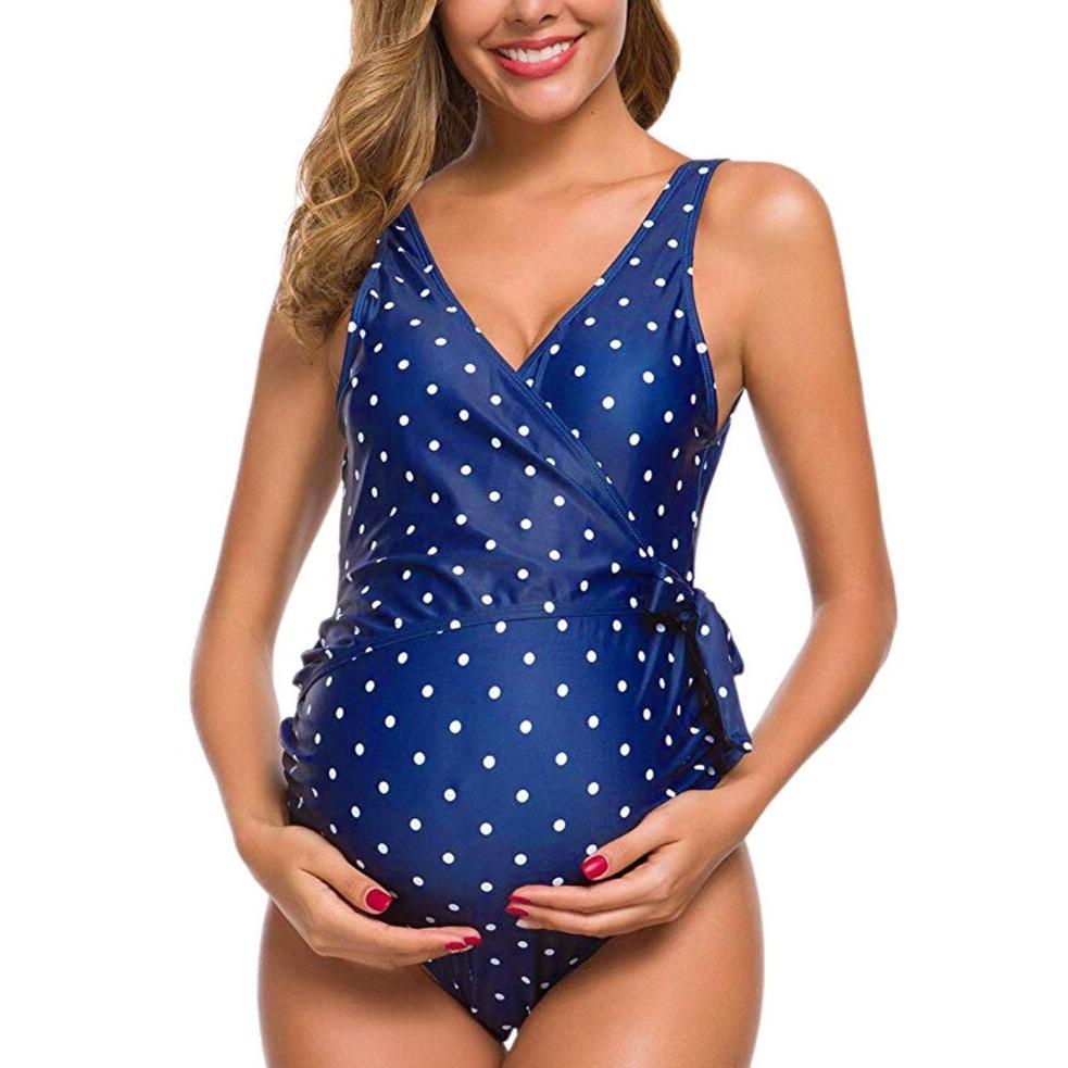 Maternity swimsuit in blue with white polka dots, featuring a wrap design. Ideal for pregnant women seeking stylish and comfortable swimwear.