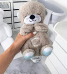 Cute plush teddy bear with soft gray fur, blue ears, and a smiling face, held in a hand. Perfect cuddly toy for kids. Ideal nursery decor.