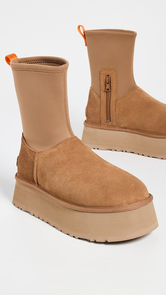 Tan suede platform boots with neoprene upper, side zipper, and orange pull tab. Stylish women's footwear, chunky sole, trendy fall fashion.