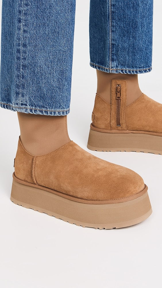 Tan suede platform ankle boots with side zipper, worn with blue denim jeans. Fashionable women's footwear, casual style, comfortable design.