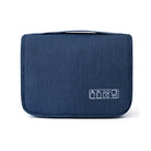 Navy blue travel toiletry bag with zipper, multiple compartments, and travel icons. Ideal for organizing toiletries, cosmetics, and travel essentials.